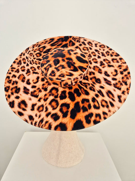 Leopard print hat on a manniquin head against a light gray background top view