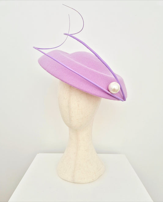 Lilac hat with a pearl on a mannequin head against a white background side front view