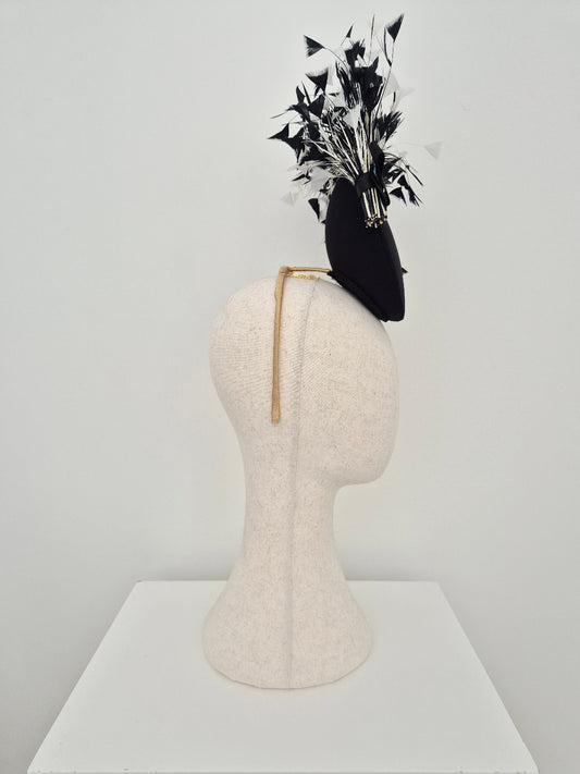 black and white feather percher headpiece side view on a manniquin head against a white background