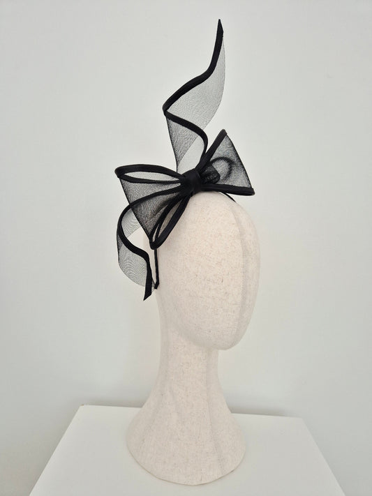 black bow headpiece on a mannequin head against a white background side view
