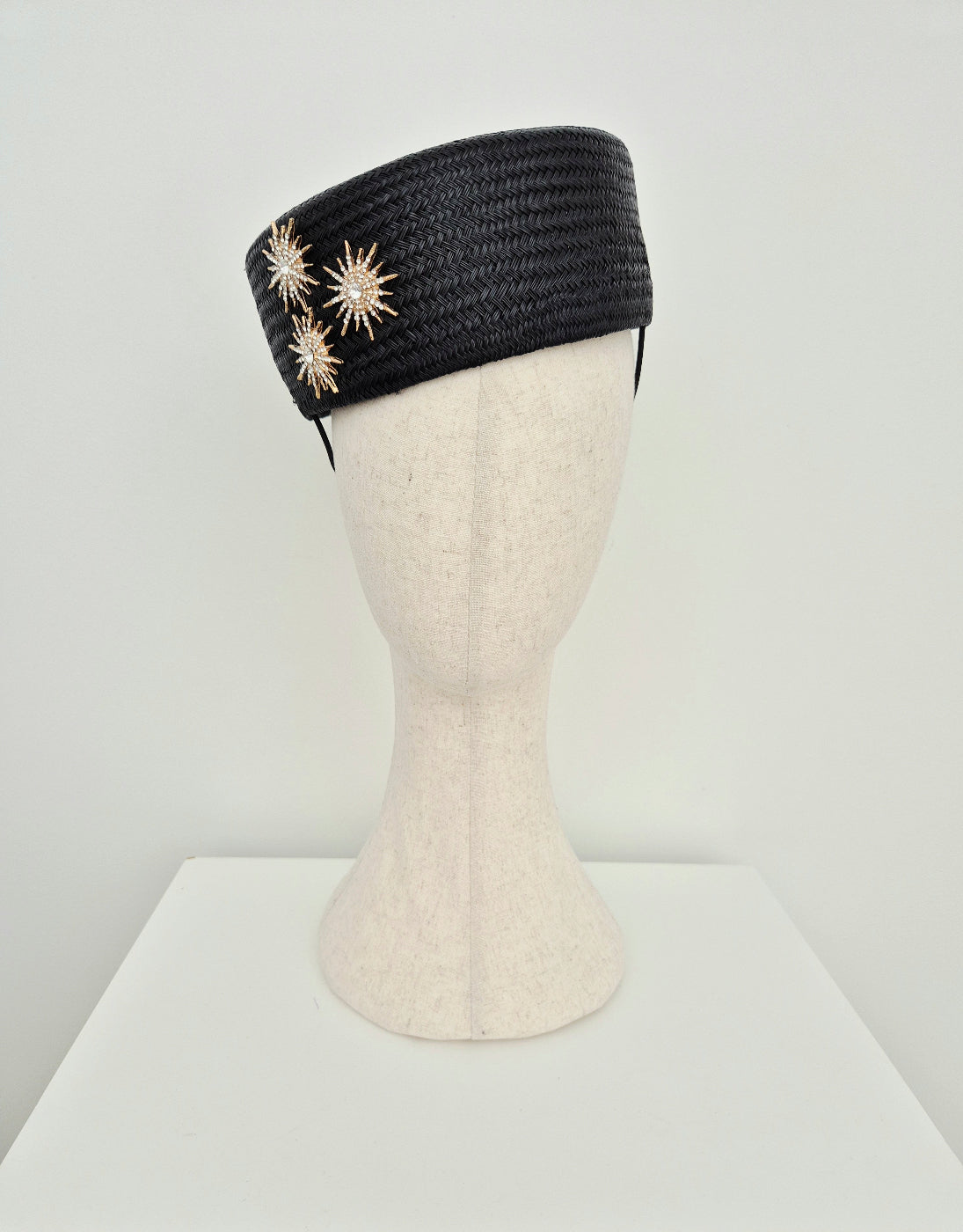 black straw pillbox headpiece with gold star detail