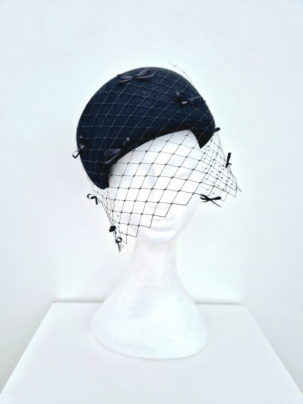 black felt headpiece with bows and veiling
