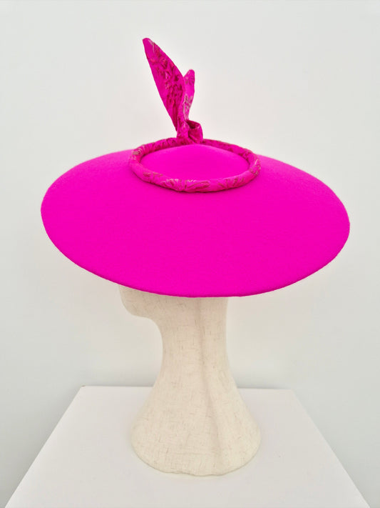 Bright pink hat on a mannequin head against a white background side view
