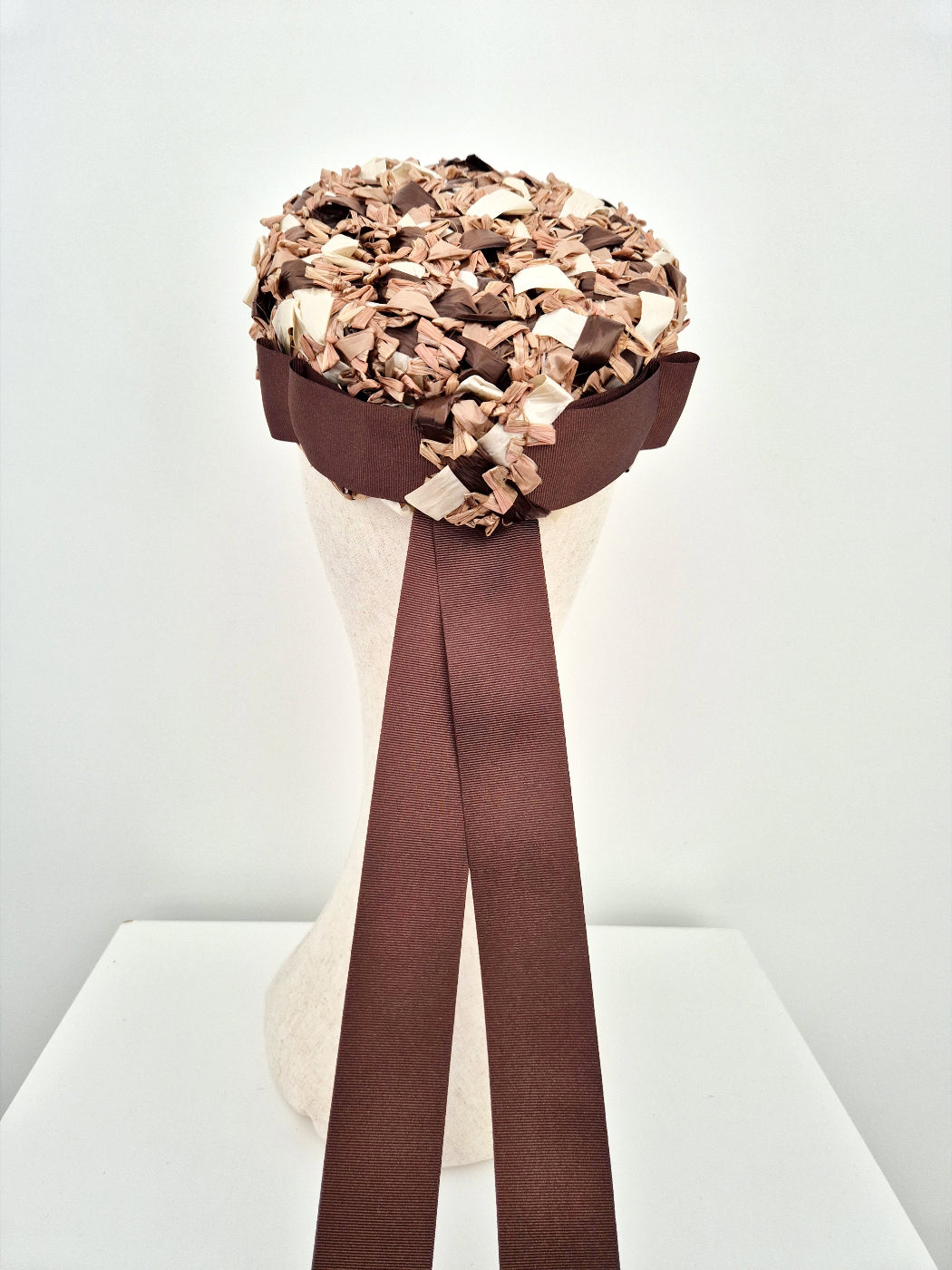 brown and cream straw rear sitting pillbox headpiece with bow and tails back view