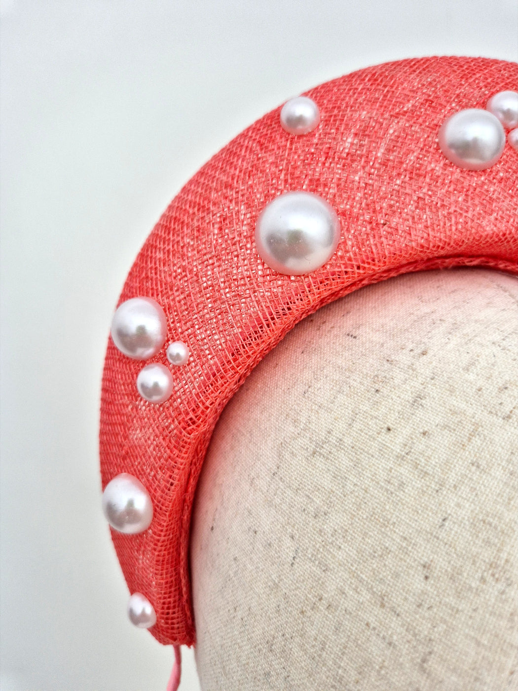 coral straw halo headpiece with pearls close up