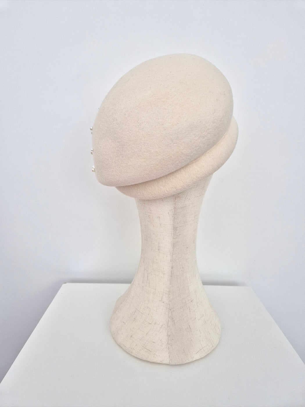 Mannequin head with beige cap on a white background