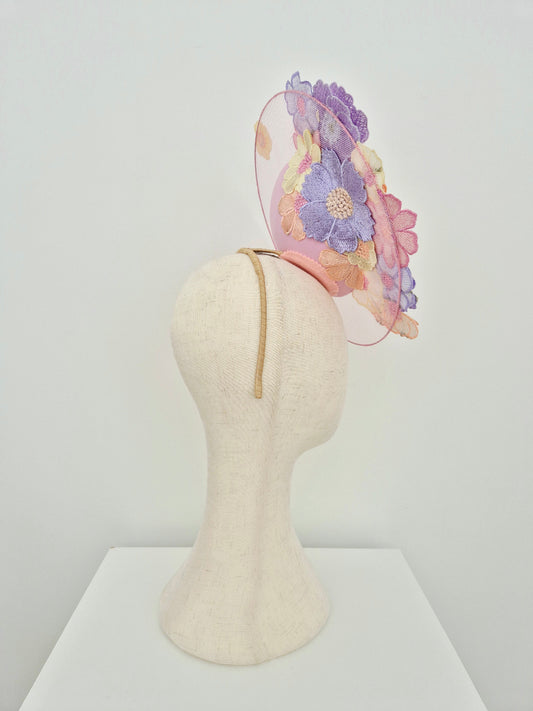 Pastel floral headband on a mannequin head against a white background side view
