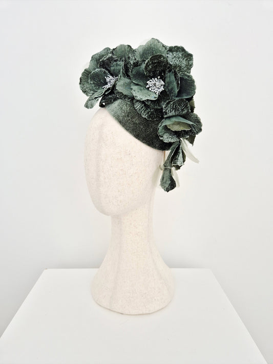 sage Green floral headpiece on a mannequin head against a white background side view
