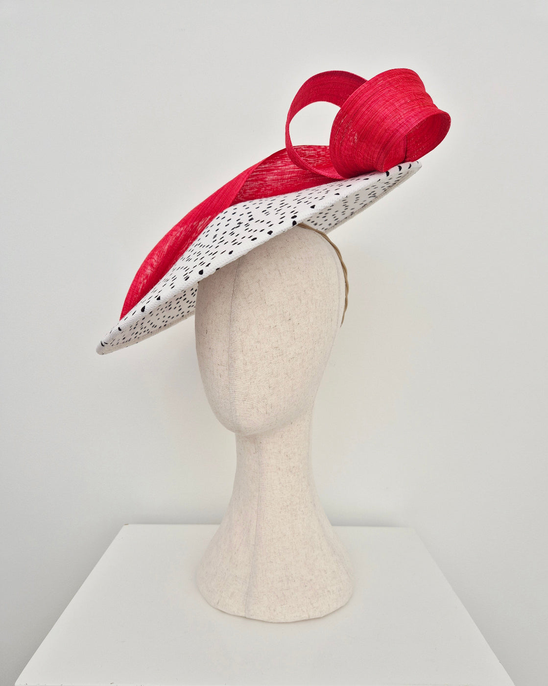 side view black and white polka dot coolie hat with red loopy tail