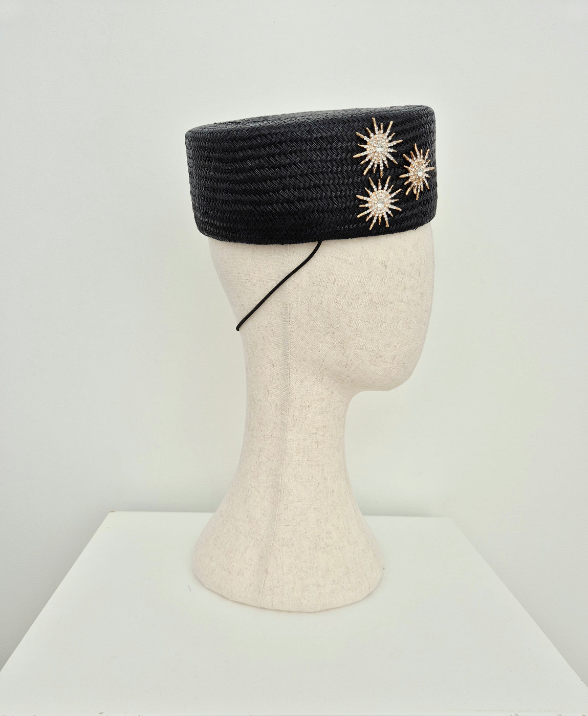 side view black straw pillbox headpiece with gold star detail