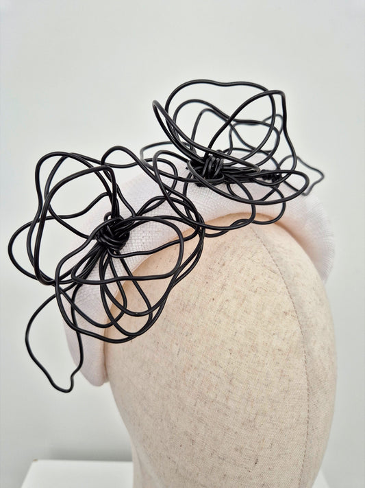 white padded straw headband with black floral wirework close up