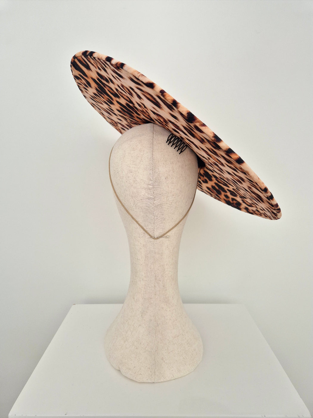 Leopard print wide-brimmed hat on a mannequin head against a white background back view
