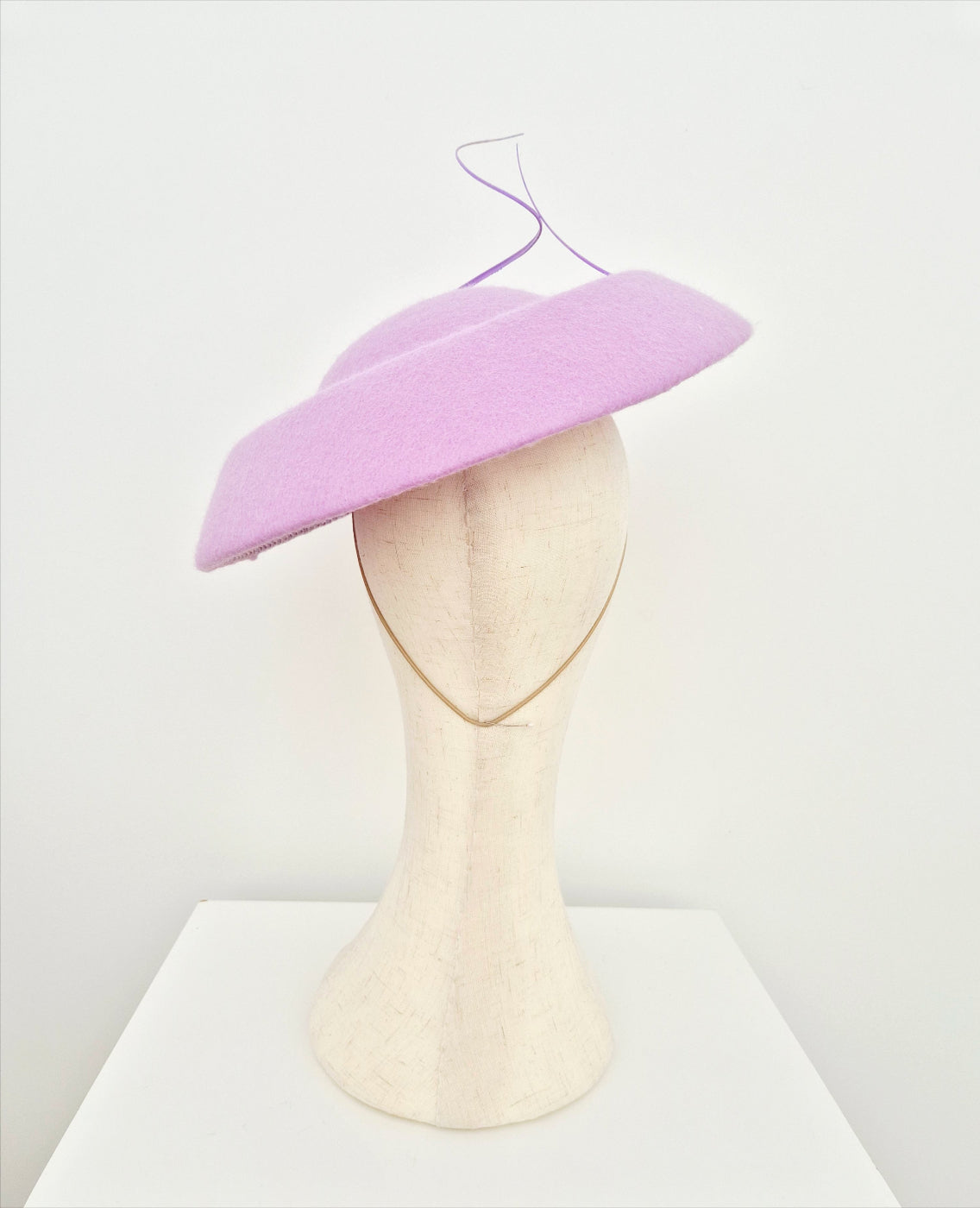 Lilac hat on a mannequin head against a white background