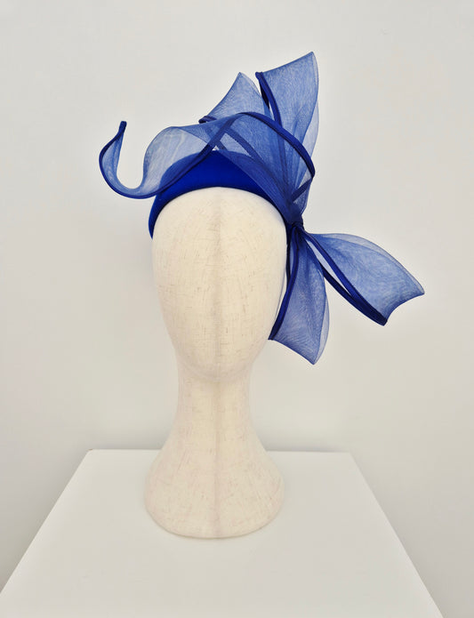 Blue felt headpiece on a mannequin head against a white background with bow