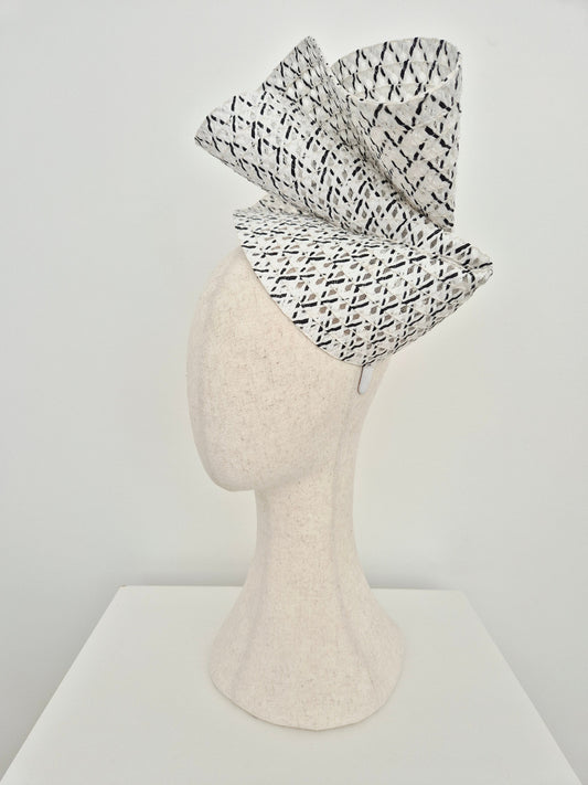 Black and white patterned headpiece on a mannequin head against a white background side view