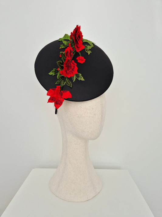 black leather percher plate headpiece with red lace floral detail on a manniquin head against a white background side view