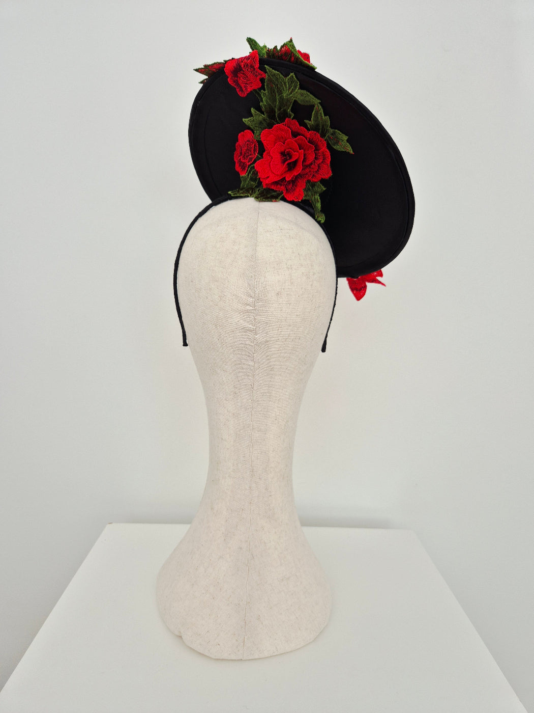 black leather  headpiece with lace rose detail on a manniquinn head back view
