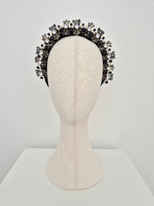 black rhinestone headband on a mannuiquin head against a white wall