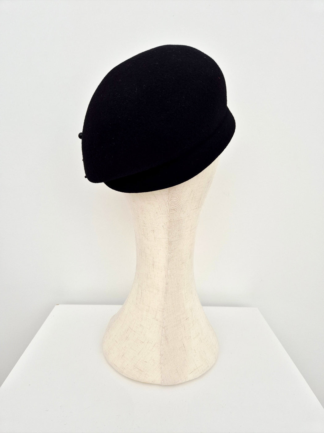 Black hat on a mannequin head against a white background