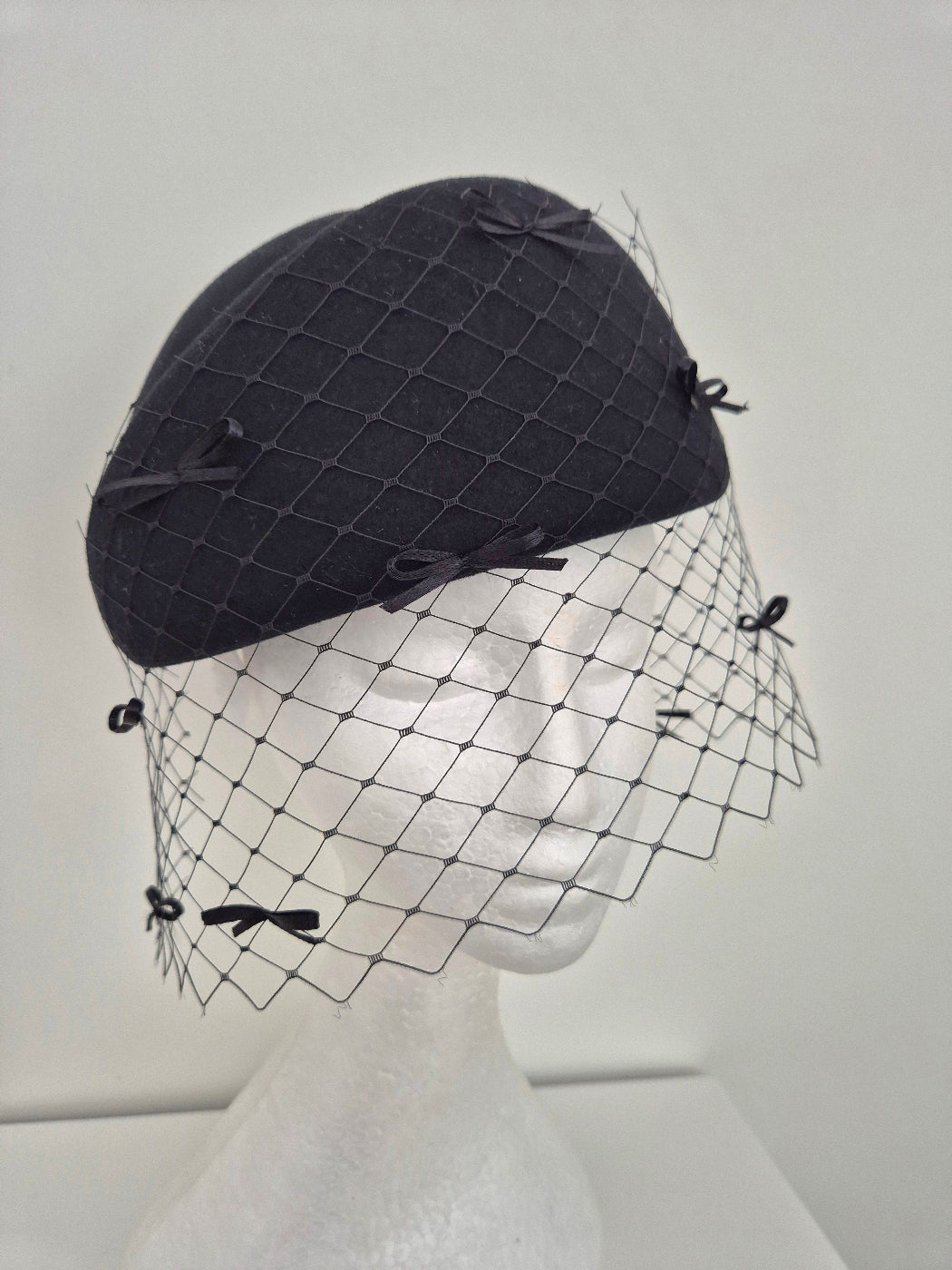 black wool felt headpiece with bows and veiling close up
