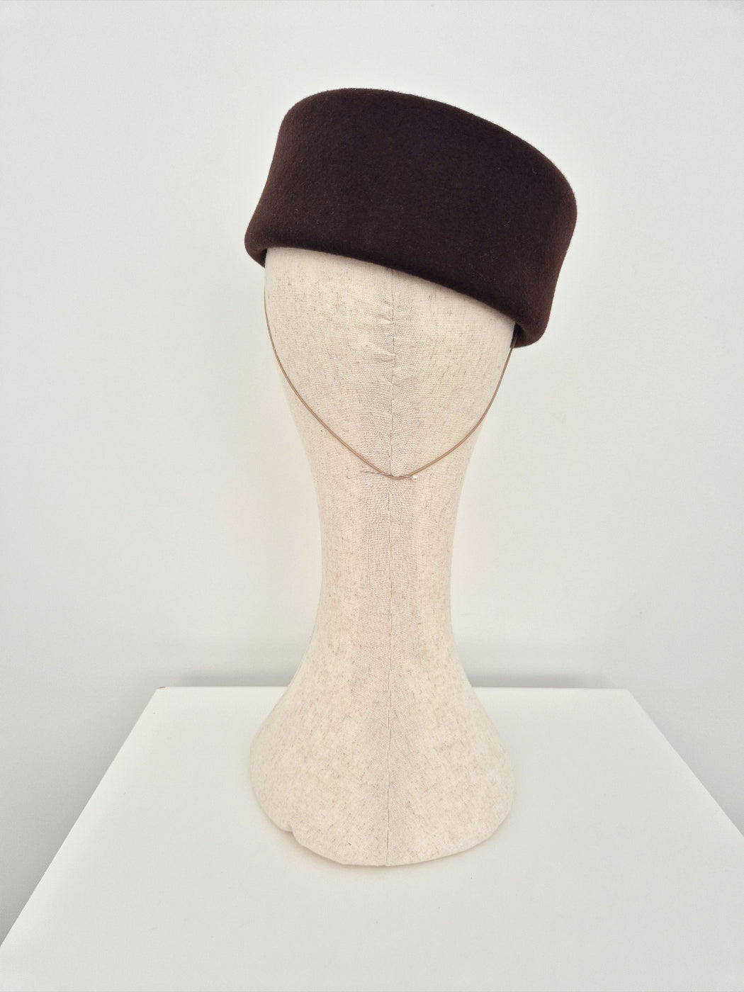 Brown hat on a mannequin head against a white background back view