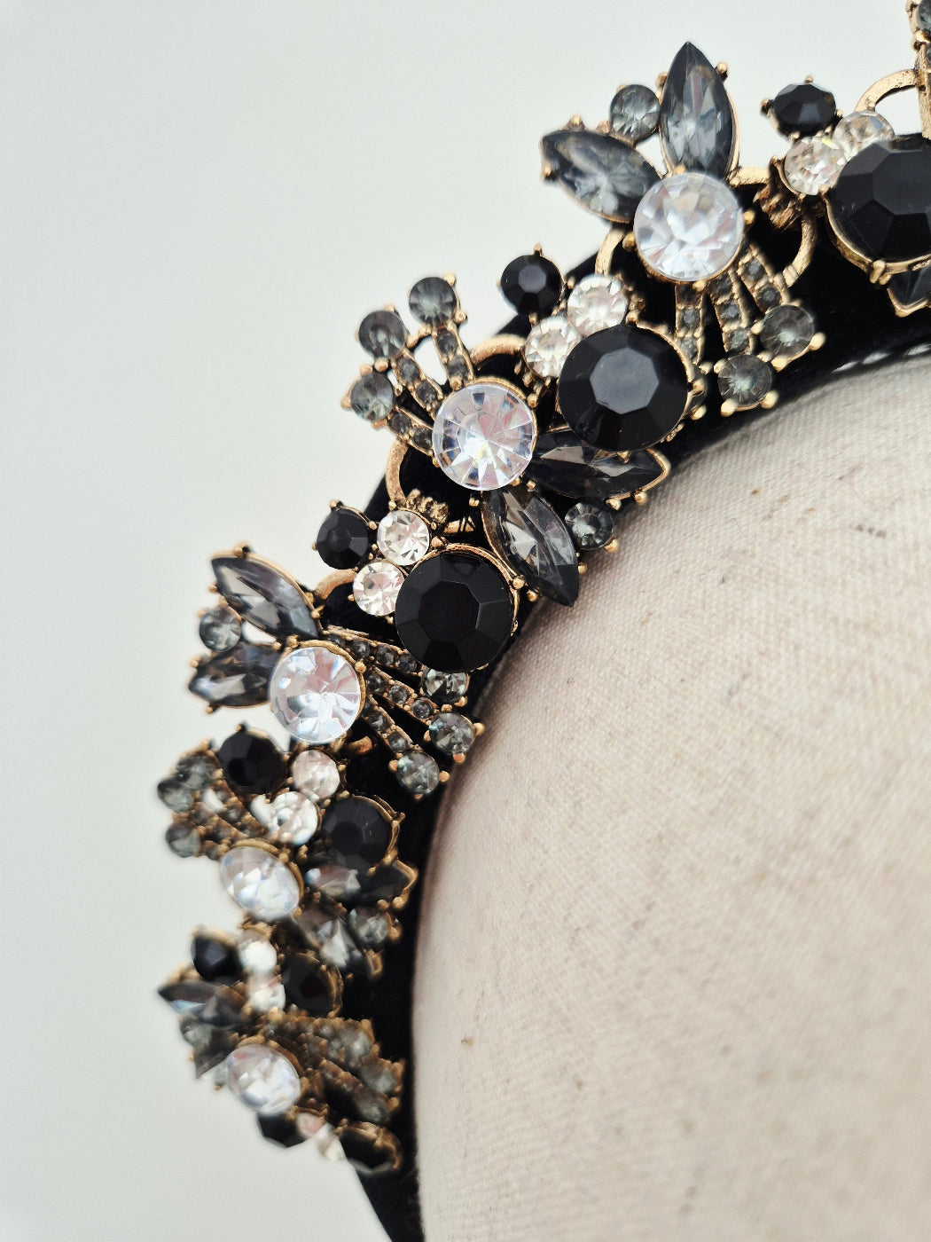 close up black rhinestone headband on a manniquin head against a white baqckground