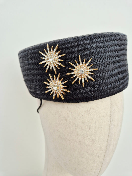 close up black straw pillbox with stars