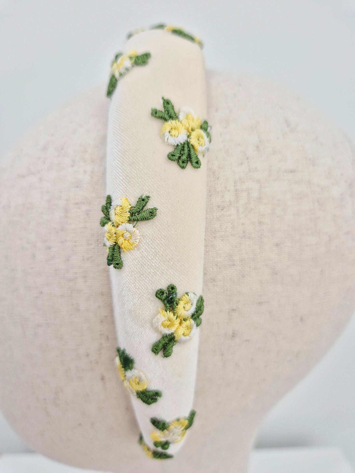 close up ivory velvet headband with yellow rosebuds