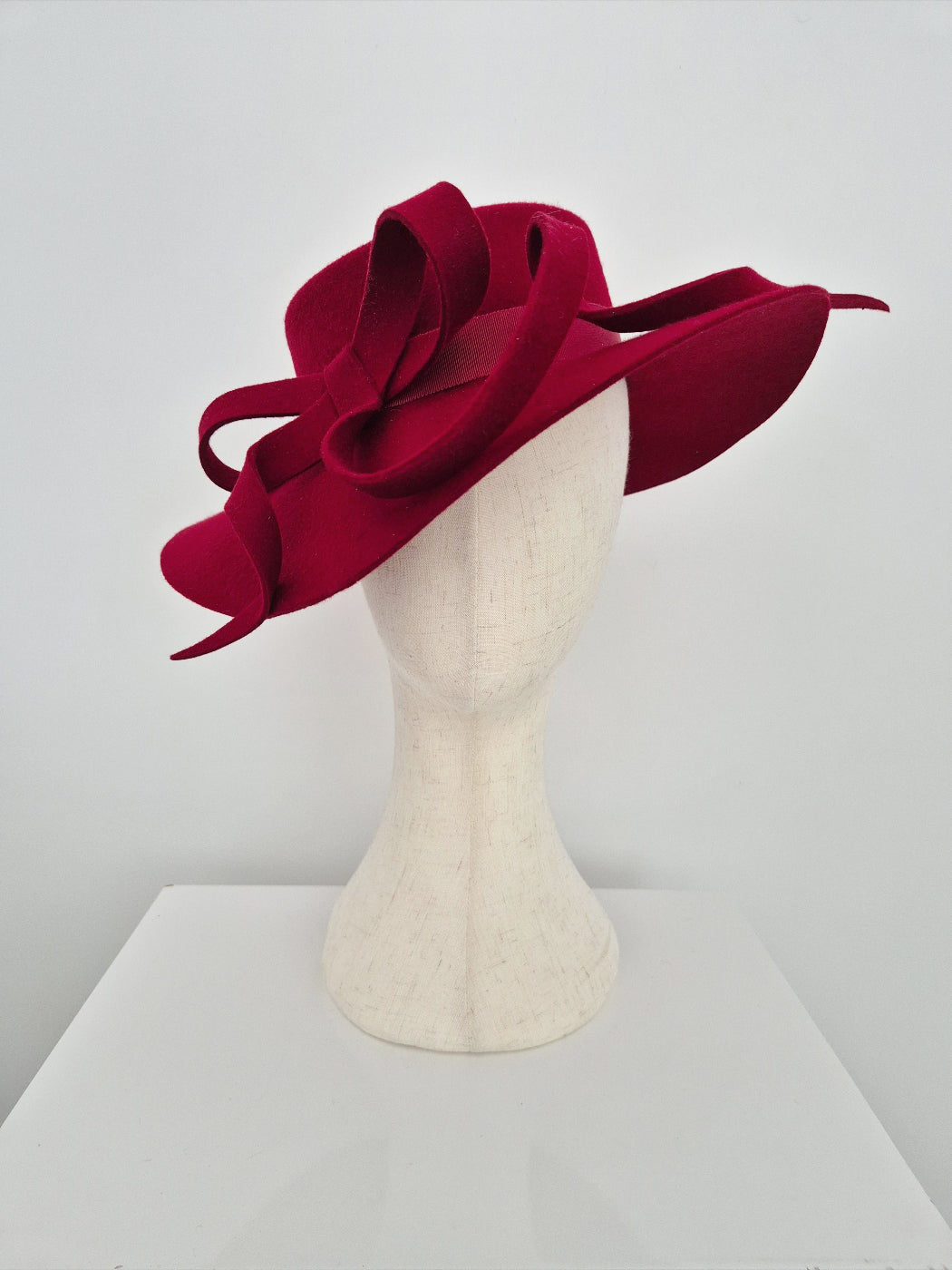 Dark Red wool felt hat on a mannequin head against a white background