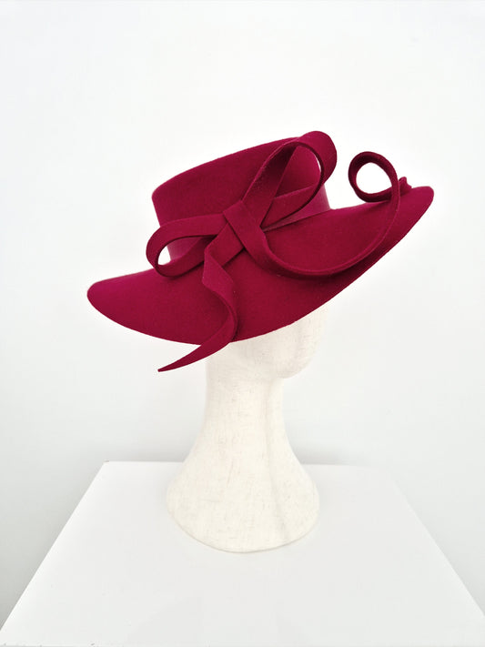 dark Red wool felt with bow hat on a mannequin head against a white background