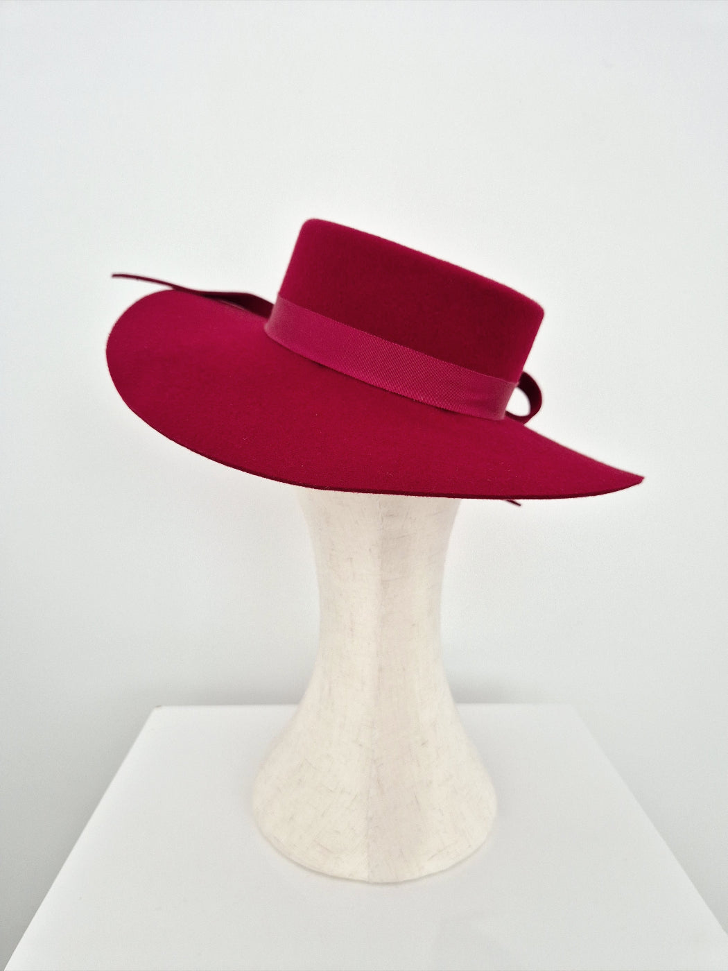 Deep Red wide-brimmed hat on a mannequin head against a white background back view
