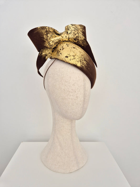 Gold and brown headpiece on a mannequin head against a white background side view
