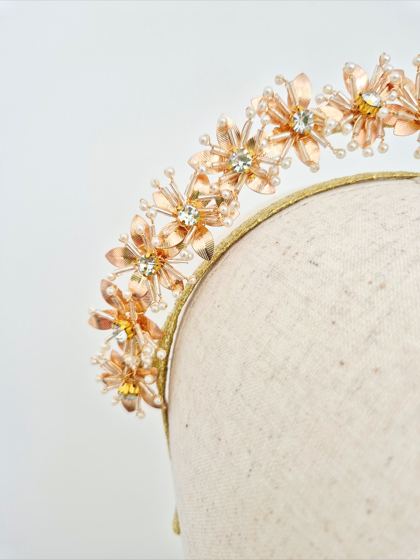 gold floral headband on a neutral background close up