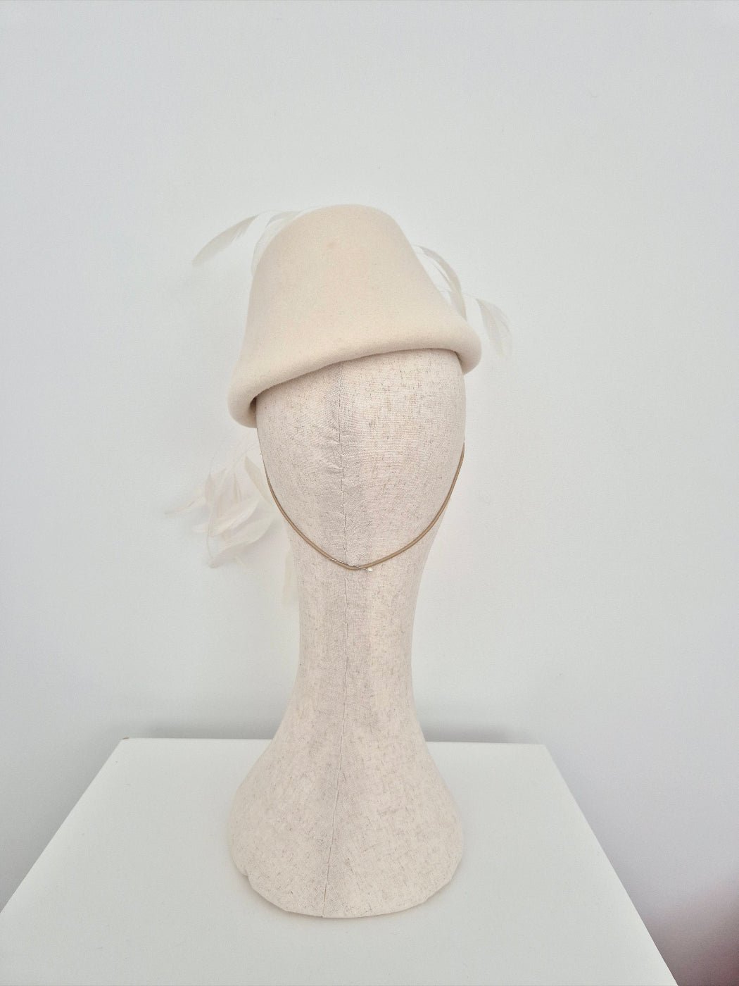 ivory headpiece on a mannequin head against a white background back view