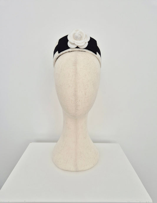 Mannequin head with a ivory tweed headpiece pillbox with a flower on a white background