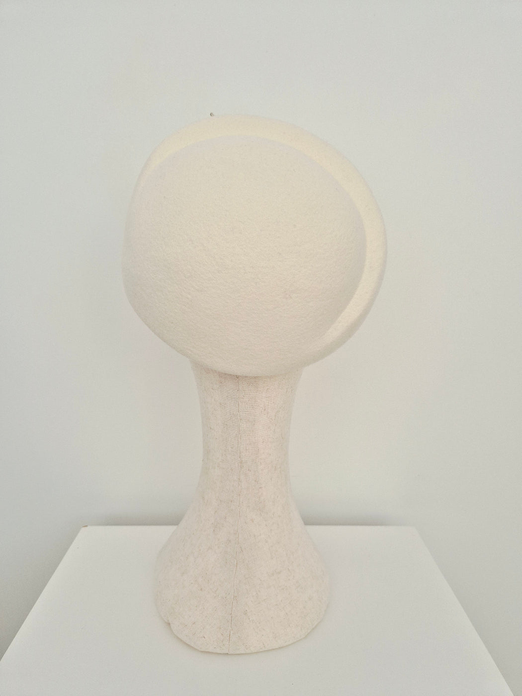 ivory wool felt beret back view on a manniquin head against a white wall