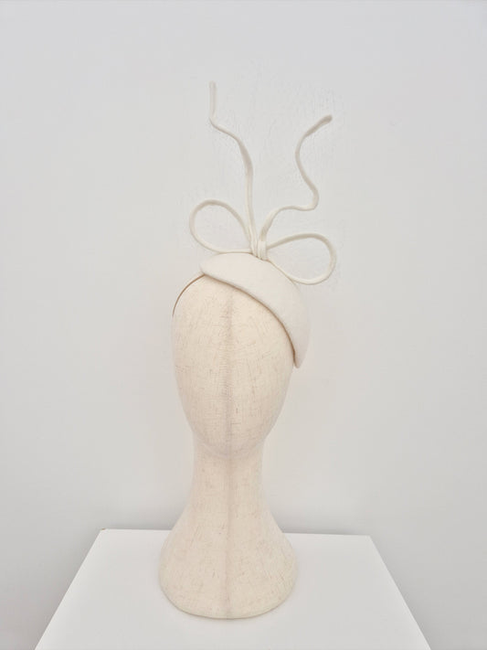Mannequin head with a ivory headpiece with a bow on a white background