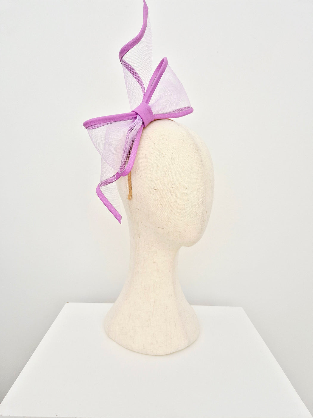 lavender bow headpiece on a mannequin head against a white background side view