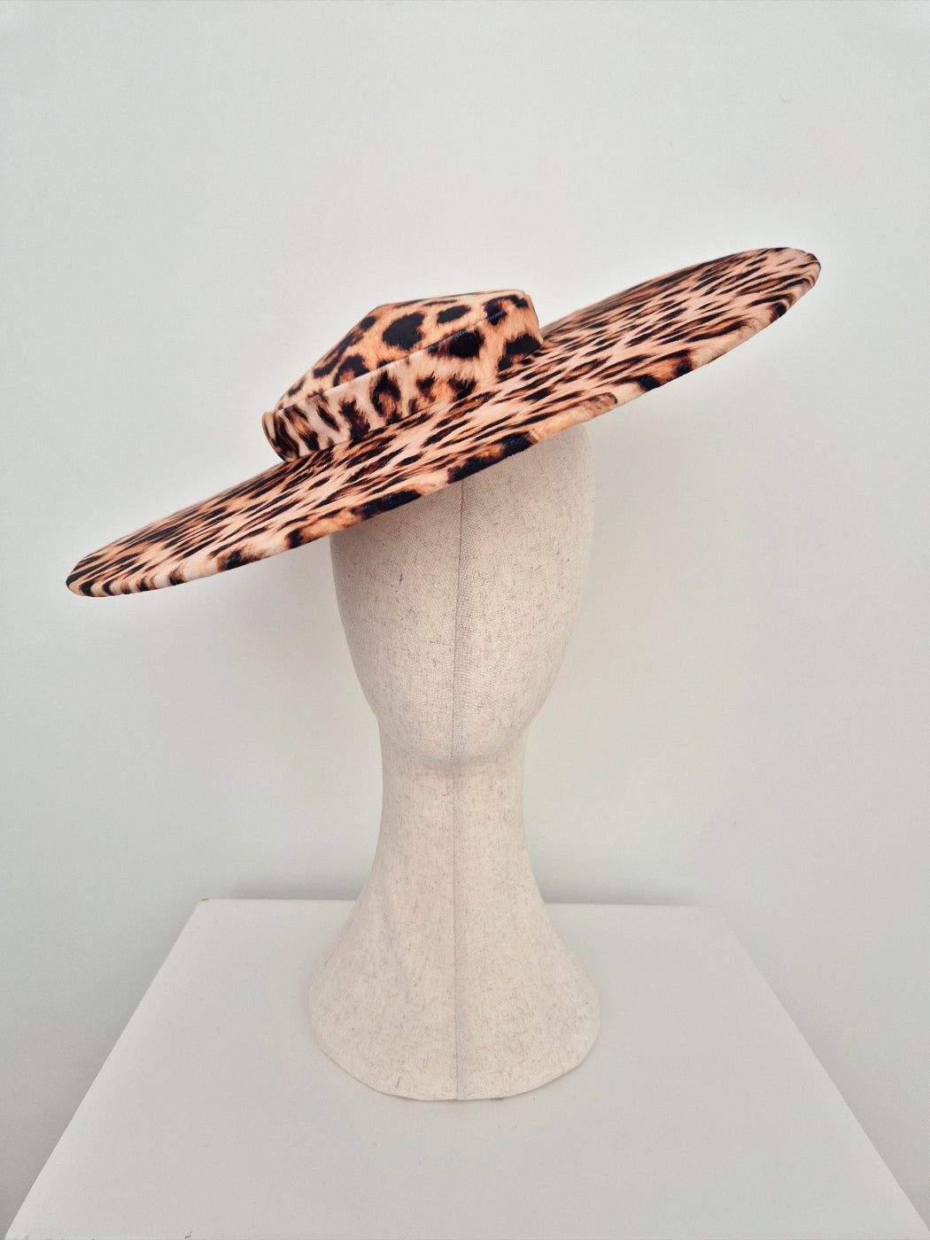 Leopard print hat on a mannequin head against a white background