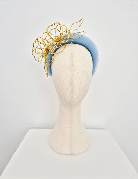 Blue and gold headpiece on a mannequin head against a white background