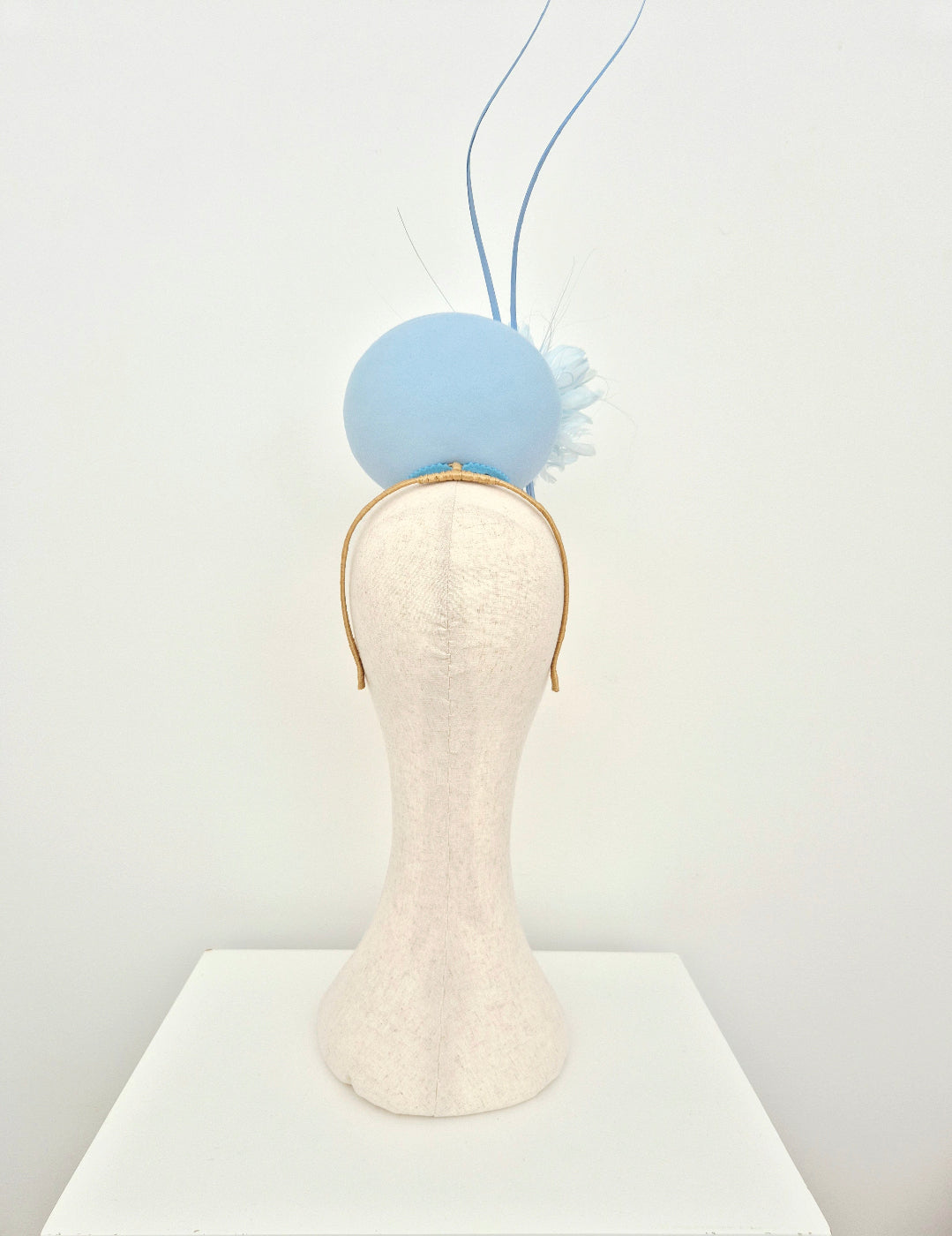 Mannequin head with a light blue headpiece back view on a white background