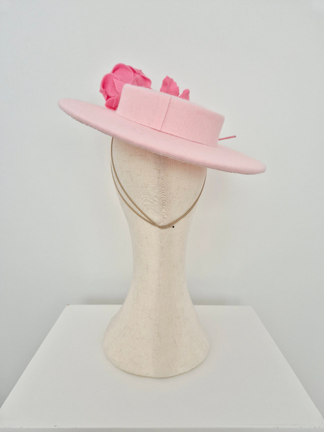 light Pink felt hat with floral details on a mannequin head against a white background back view