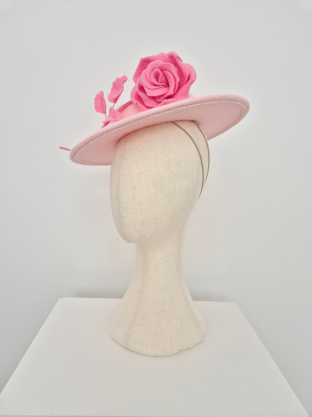 light Pink felt hat with a pink rose flower  stem on a white background side view