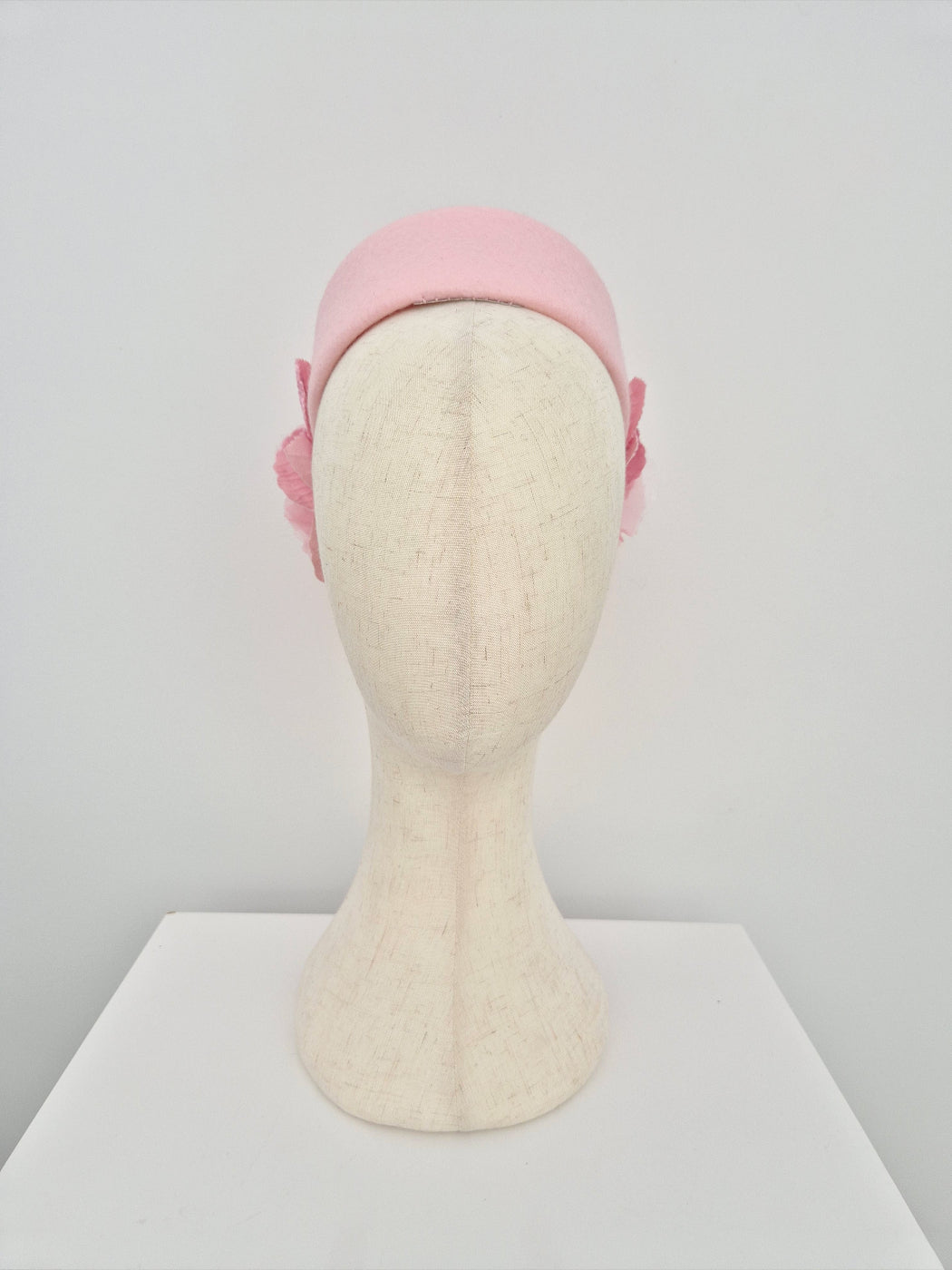 Pink pillbox headpiece on a mannequin head against a white background front view