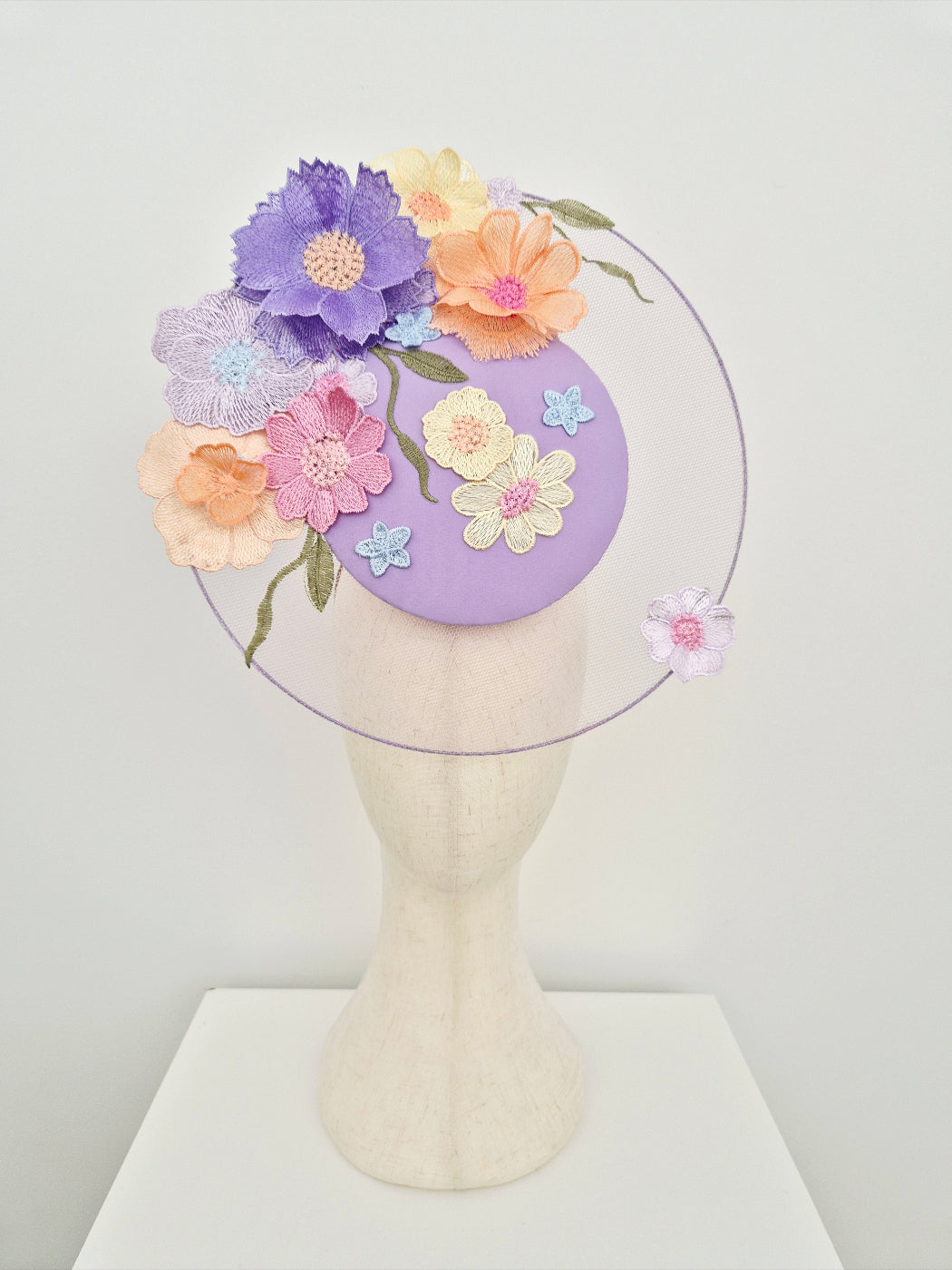 lilac and Pastel floral headpiece  on a mannequin head against a white background