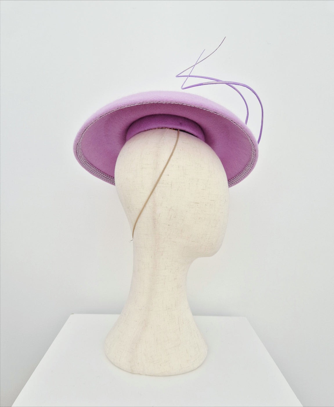 lilac hat on a mannequin head against a white background under side view