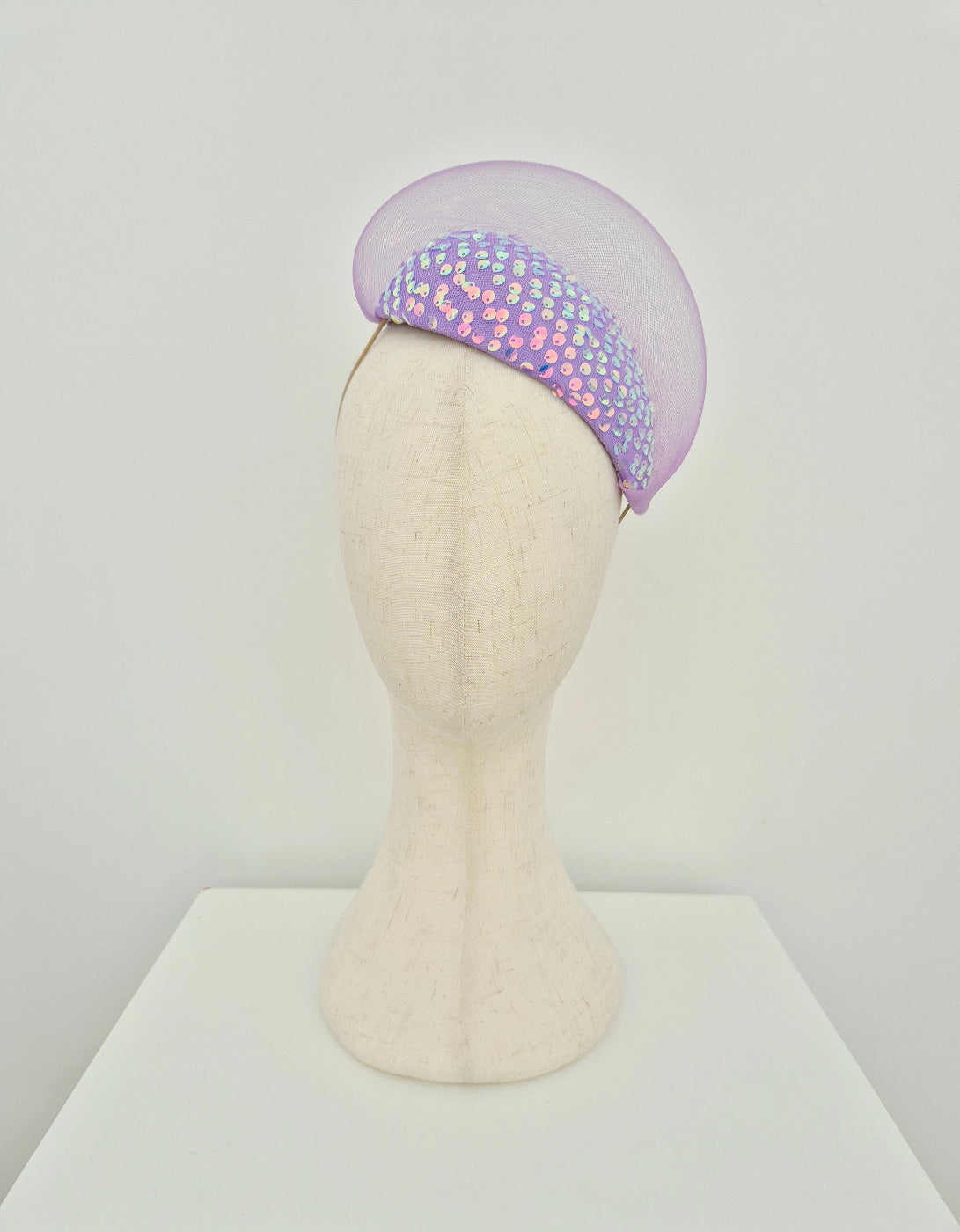 Lilac headpiece with sequin details on a mannequin head against a white background front
