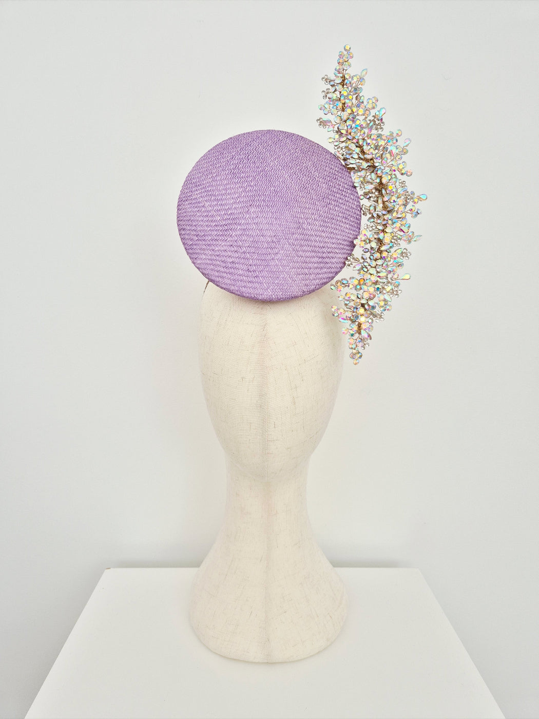 Lavender hat with decorative headband on a mannequin head against a white background
