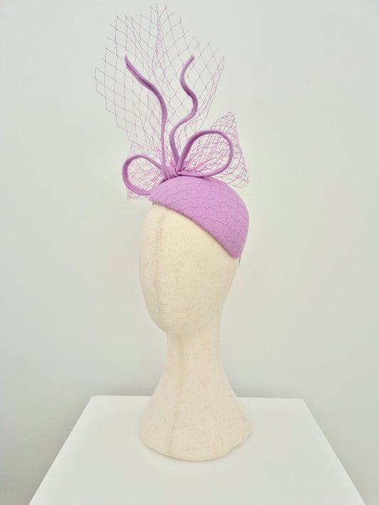 Lilac headpiece with decorative bow on a mannequin head against a white background side view