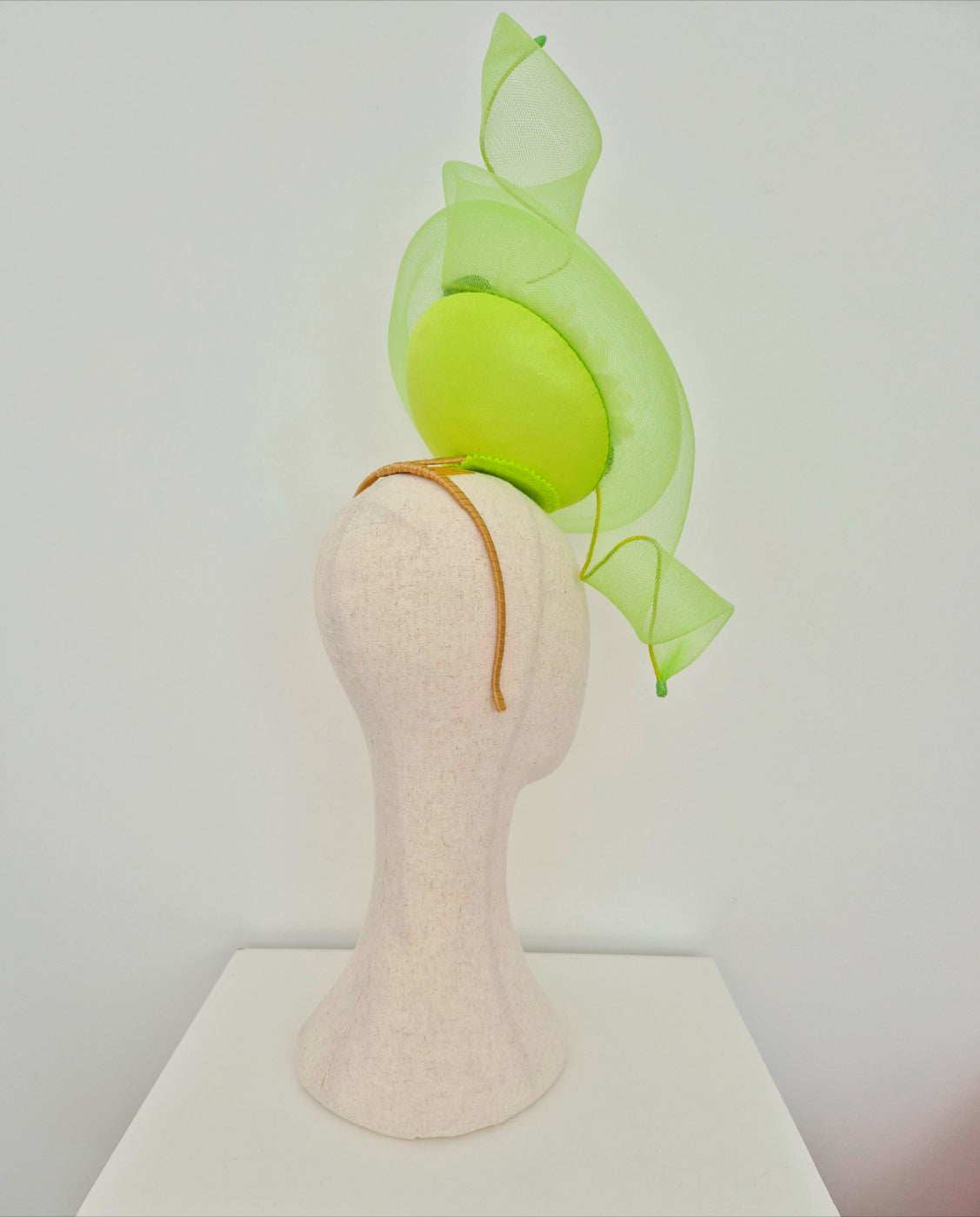 Lime Green percher headpiece on a mannequin head against a white background  side back